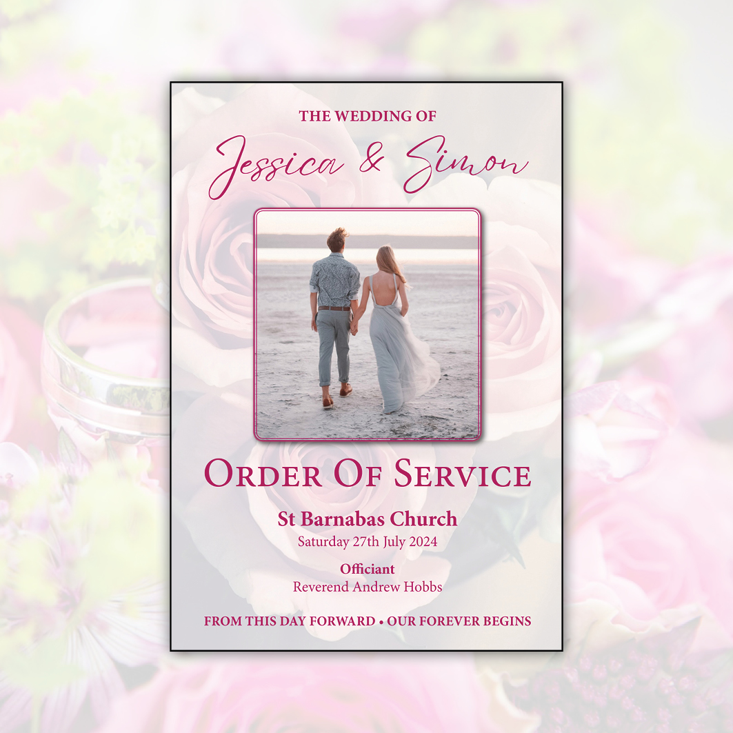 Front cover of a wedding order of service featuring a photo of the happy couple on a beach, adorned with a rose design and set against a floral and wedding ring backdrop. Created by Orchid Memories