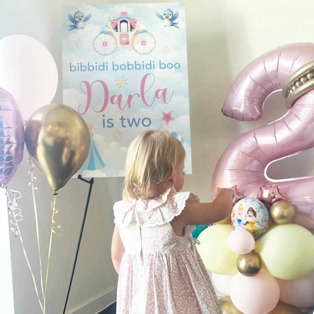 Cinderella themed welcome sign at a birthday party, featuring the little birthday girl surrounded by colourful balloons. Created by Orchid Memories
